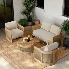 an outdoor living area with wicker furniture and potted plants