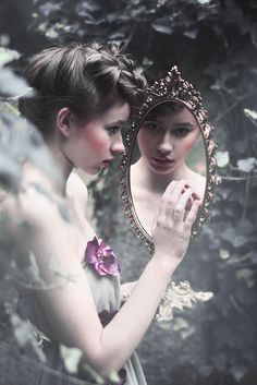 two women looking at themselves in a mirror