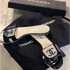 These Chanel Mules Are Black Patent With Pvc. Size 38 In Great Condition. Wear Only To Bottom As Only Worn A Few Times. Perfect For Any Outfit. Comes With Dust Bag For Each Shoe And Box. Elegant Black Slide Sandals, Elegant Black Slides For Evening, Luxury Black Slide Sandals, Luxury Formal Flat Slides, Luxury Black Flat Slides, Black Luxury Flat Slides, Elegant Black Slides With Branded Insole, Designer Black Flat Slides, Black Designer Flat Slides