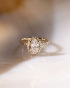 a diamond ring sitting on top of a white surface with the light shining through it