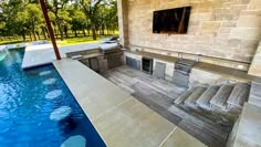 an outdoor kitchen next to a swimming pool