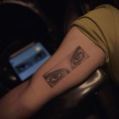 a woman's arm with an eye tattoo on it