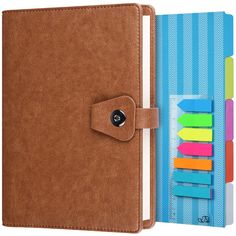 a brown leather notebook with sticky notes attached to the front and back cover, next to an assortment of colored pencils