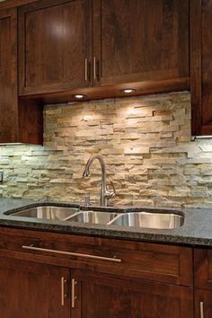 a kitchen with dark wood cabinets and granite counter tops, along with a stainless steel sink