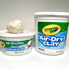 two buckets of air dry clay next to each other on a white table top