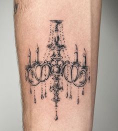 a black and white photo of a chandelier tattoo