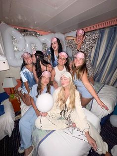 a group of women pose for a photo in front of an inflatable bed