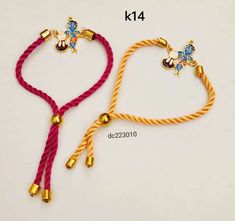 two bracelets with bells and beads are shown on a white surface, one is yellow and the other is red