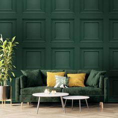 a living room with green walls and two tables in front of the couch, coffee table and potted plant