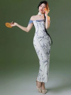 a woman in a white and blue dress is holding a cookie up to her ear