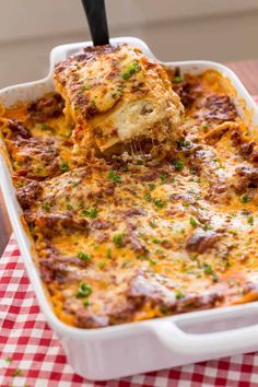 lasagna casserole being lifted from the casserole dish with a spatula