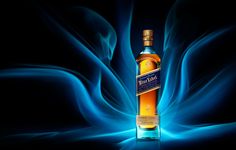 a bottle of whisky sitting on top of a blue and black background with swirls