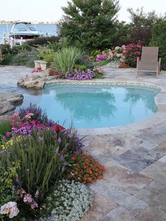 an outdoor pool surrounded by flowers and plants