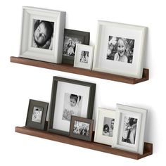 two wooden shelves with pictures on them and one shelf holding three different frames, the other is empty