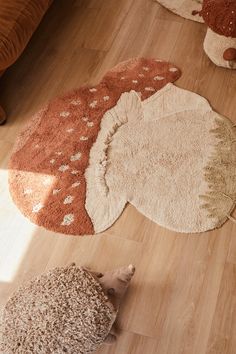 three rugs are on the floor in front of a couch and teddy bear toy