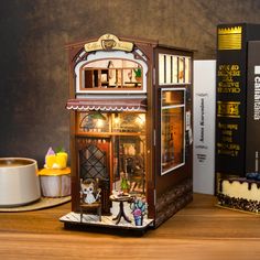 a miniature doll house on a table next to some books