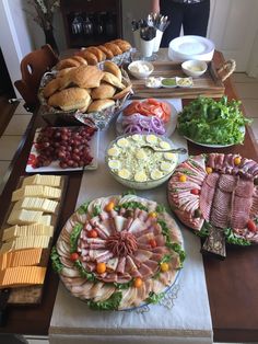 a table filled with different types of food on plates and trays next to each other