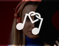 a woman with headphones on holding a record in front of her face and the word music