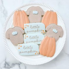 decorated cookies on a plate with little pumpkins and little pumpkin tags in the middle