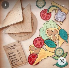 some cut out food items on a table with a piece of paper next to it