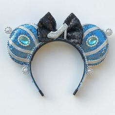 a blue and silver mouse ears headband with a number one on the side, decorated with pearls