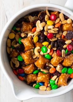 a white bowl filled with candy and nuts