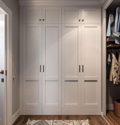 a walk in closet with lots of white cabinets and drawers on the wall next to a rug