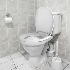 a white toilet sitting in a bathroom next to a roll of toilet paper