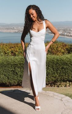 a woman in a white dress posing for the camera