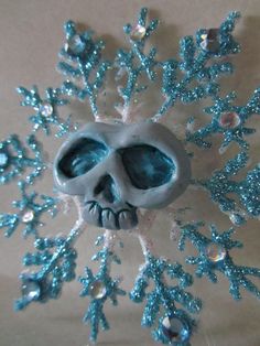 a snowflake that looks like a skull with blue eyes and mouth is shown