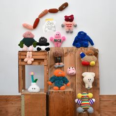 several stuffed animals are displayed on wooden crates