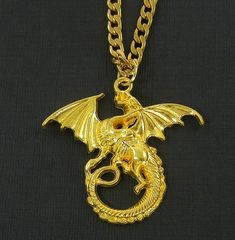 This shiny gold plated winged dragon makes a great statement pendant necklace for you. The detailed 3D pendant is hollow on the back, making the necklace light of weight. This unique and captivating piece is a true merger of fantasy and style. Bring a touch of enchantment to your everyday! Pendant measurements - 1 3/4 inches (44mm) long; 1 13/16 inches (46mm) wide Necklace weighs approx. 8 grams  (depending on chain)                                               approx. same weight as a US 25cen Everyday Pendant, Winged Dragon, 3d Pendant, Dragon Wings, Dragon Pendant, Statement Pendant, Bright Gold, Unisex Jewelry, Jewellery Design