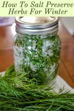 a jar filled with lots of green stuff on top of a table