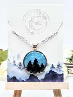 This one of a kind Round Tree pendant was handmade out of polymer clay and and sealed with resin for a durable finish. The chain is high quality stainless steel. If you have questions about this product or if you want to inquire about creating a custom order please don't hesitate to reach out! Hand Painted Resin Jewelry For Gifts, Themed Stainless Steel Jewelry As Gift, Hand Painted Nature-inspired Necklace For Gift, Nature-inspired Hand Painted Necklace For Gift, Nickel-free Resin Round Pendant Jewelry, Hand Painted Resin Pendant Jewelry, Hand Painted Silver Polymer Clay Necklace, Silver Polymer Clay Pendant Necklace, Unique Resin Necklace Nickel Free