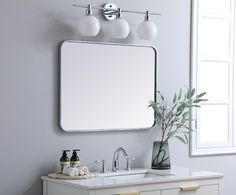 a bathroom with a sink, mirror and two lights on the wall next to it