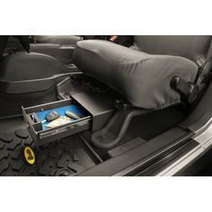 the inside of a car with an electronic device in the back seat and storage compartment