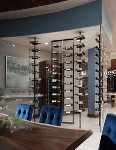 a dining room filled with blue chairs next to a wine rack