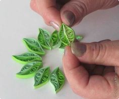 someone is making some paper flowers out of green leaves