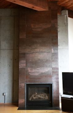 a living room with a fire place in the center and a tv on top of it