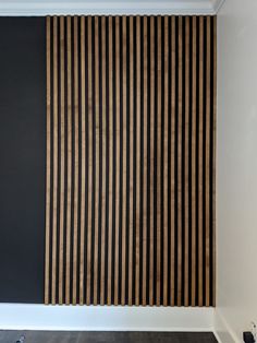 an empty room with black walls and wooden slats