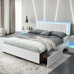 a white bed sitting in a bedroom next to a night stand with lights on it