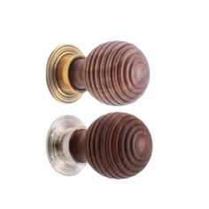 two wooden knobs on the front of a door, one with an oval design