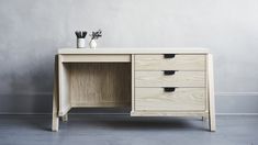 a wooden desk with two drawers and vases on top