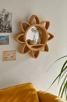 a living room with a yellow couch and a round mirror on the wall above it