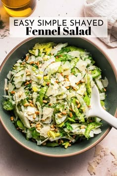 a bowl filled with shaved fennel salad next to a glass of beer and napkin