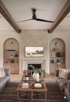 a living room filled with furniture and a fire place next to a wall mounted tv