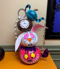 an odd looking clock sitting on top of a colorful ball with bunny ears and eyes