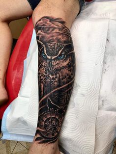 an owl and compass tattoo on the arm