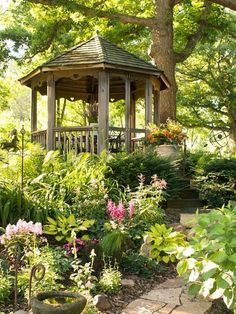 a gazebo surrounded by flowers and trees