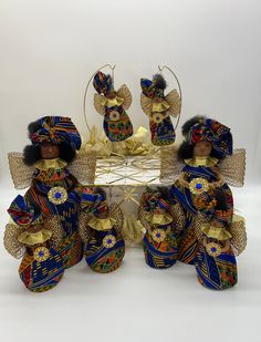 three figurines sitting on top of a table with gold trimming and blue fabric